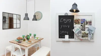 a dining room with a table and a clock at Happy Apartments in Barcelona