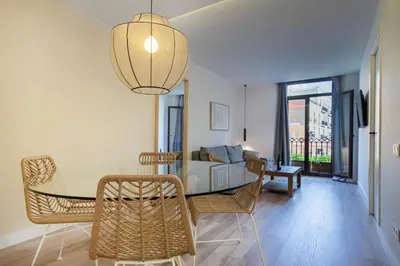 a dining room with a table and chairs and a couch at Happy Apartments in Barcelona
