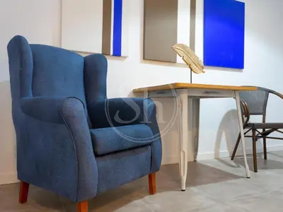 a blue chair next to a table with a lamp at Apartamento para dos en Gracia in Barcelona
