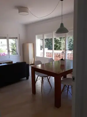 a living room with a wooden table and chairs at Alt Penedes, terra de vinya, sol, aigua i muntanya in Torrellas de Foix