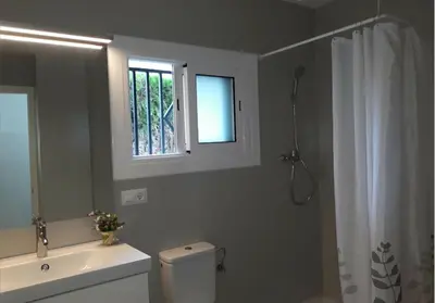 a bathroom with a toilet and a sink and a window at Alt Penedes, terra de vinya, sol, aigua i muntanya in Torrellas de Foix