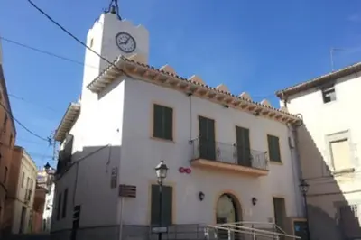 a building with a clock tower on top of it at Alt Penedes, terra de vinya, sol, aigua i muntanya in Torrellas de Foix