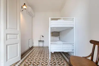 a room with a white bunk bed and a chair at B41 - Apartamento para grandes grupos en BCN centro in Barcelona