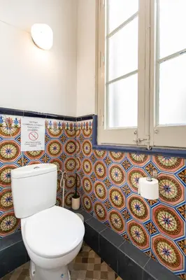 a bathroom with a toilet and colorful tiles on the wall at B41 - Apartamento para grandes grupos en BCN centro in Barcelona