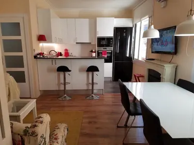 a kitchen and living room with a table and chairs at Apart 2 bedrooms 2 bathroom 30 nigth min WiFi washmachime elevator AC heather in Barcelona