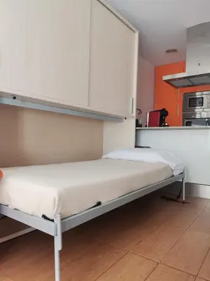 a bed in a room with a kitchen at Apartamento centrico en Calella in Calella