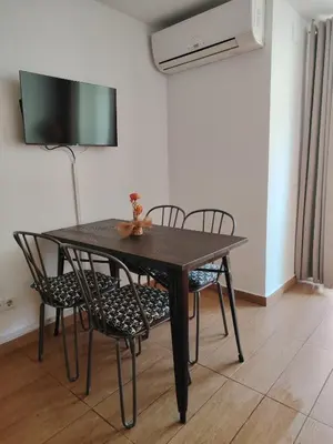 a dining room table with chairs and a television at Apartamento centrico en Calella in Calella