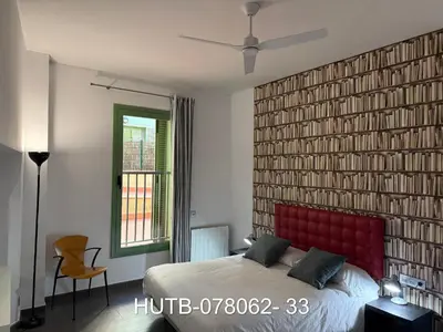 a bedroom with a large brick wall with a red headboard at Palau de la música 2 in Barcelona