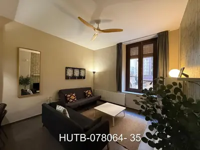 a living room with a couch and a ceiling fan at Palau de la música 4 in Barcelona