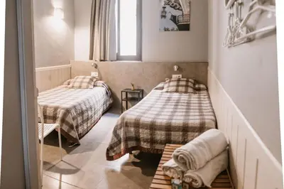 a small room with two beds and a window at Pensión 45 in Barcelona