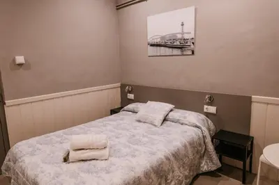 a bedroom with a bed with two towels on it at Pensión 45 in Barcelona