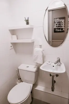 a white bathroom with a toilet and a sink at Pensión 45 in Barcelona