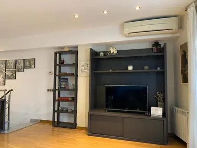 a living room with a flat screen tv and a entertainment center at Stylish Duplex Loft with terrace in Barcelona