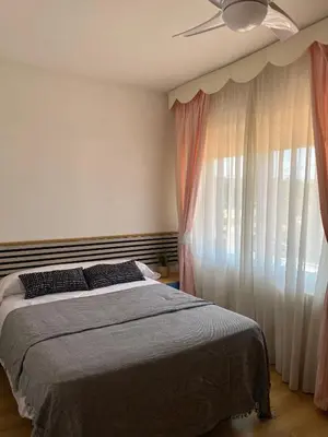 a bedroom with a bed and a large window at Villa Isabel Sitges, Rocamar in Sant Pere de Ribes