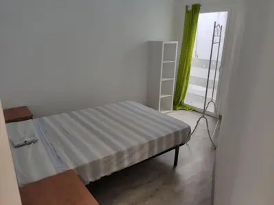 a small bedroom with a bed and a window at Apartment 3 minutes from the beach and train station on foot in Canet de Mar