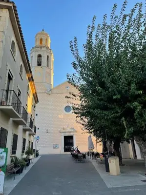 a church with a clock tower and a tree at Have Fun Apartment in Cubelles in Cubelles