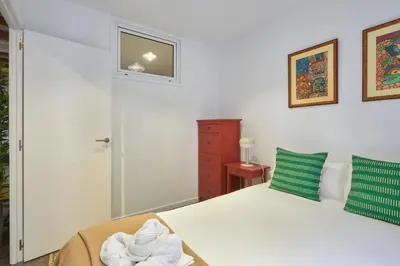 a bedroom with a white bed with a green pillow at 64 Apartment in a typical Barcelona's old building in Barcelona
