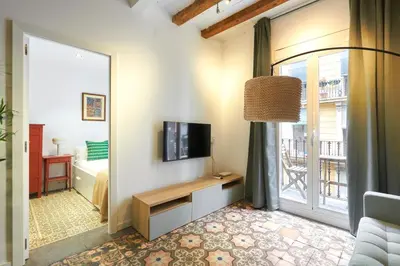 a living room with a television and a large window at 64 Apartment in a typical Barcelona's old building in Barcelona