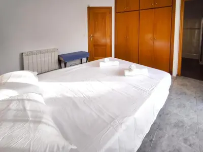 a white bed with two towels on top of it at Casa en alquiler vacacional Vilanova i la Geltrú in Vilanova i la Geltrú