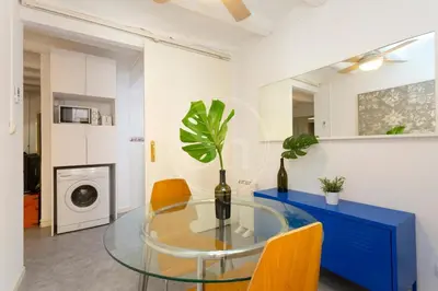 a dining room with a glass table and yellow chairs at Alojamiento en el barrio de gracia in Barcelona
