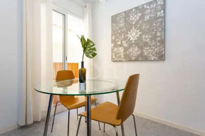 a dining room with a glass table and chairs at Alojamiento en el barrio de gracia in Barcelona
