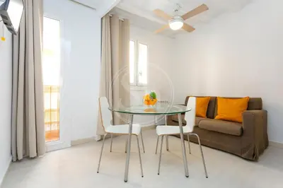 a dining room with a glass table and a couch at Estudio en Barrio de Gracia E4 in Barcelona