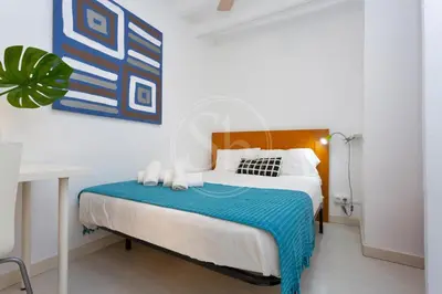 a bedroom with a bed with a blue blanket at Estudio en Barrio de Gracia E4 in Barcelona