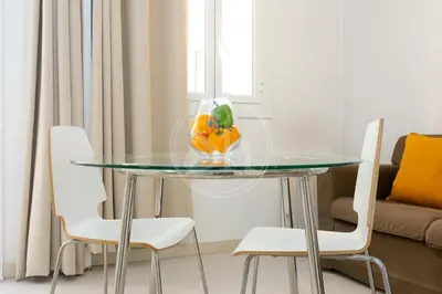 a glass table with a vase of oranges on top at Estudio en Barrio de Gracia E4 in Barcelona