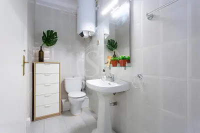a white bathroom with a toilet and a sink at Estudio en Barrio de Gracia E4 in Barcelona