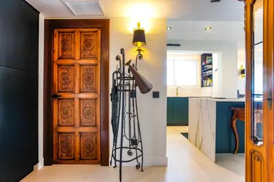 a room with a wooden door and a kitchen at Infinity Jupi Sea in Sitges