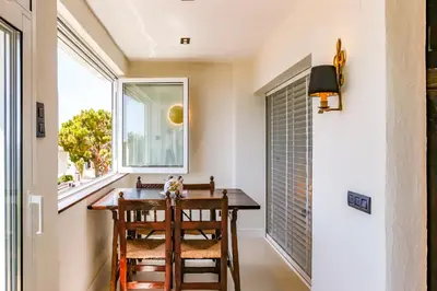 a dining room with a table and chairs and a window at Infinity Jupi Sea in Sitges