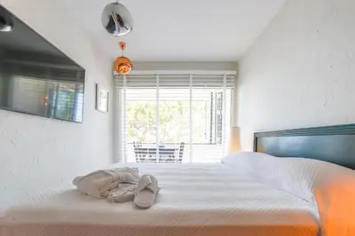 a bedroom with a bed with two shoes on it at Infinity Jupi Sea in Sitges