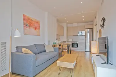 a living room with a blue couch and a table at Aspasios Arc de Triomf Apartments in Barcelona