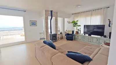 a living room with a large couch and a television at Casa Blanca in Sant Cebrià de Vallalta