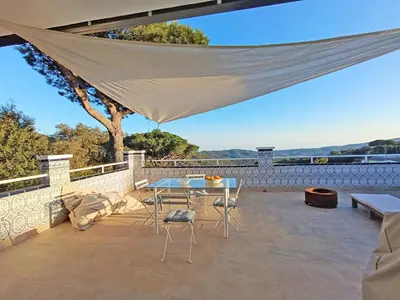 a patio with a table and chairs on a roof at Casa Blanca in Sant Cebrià de Vallalta