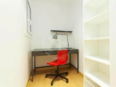 a desk with a red chair in a closet at Bonito apartamento en el Eixample in Barcelona
