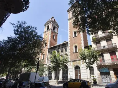 a large building with a clock tower on a street at Bonito apartamento en el Eixample in Barcelona