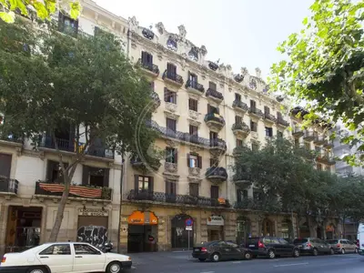 a large building with cars parked in front of it at Bonito apartamento en el Eixample in Barcelona