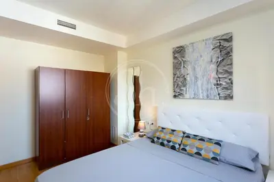 a bedroom with a bed and a painting on the wall at Cómodo apartamento junto a Hospital Sant Pau in Barcelona