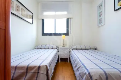 two twin beds in a room with a window at Cómodo apartamento junto a Hospital Sant Pau in Barcelona