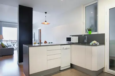 a kitchen with white cabinets and a microwave at BBarcelona Aragó Flat in Barcelona