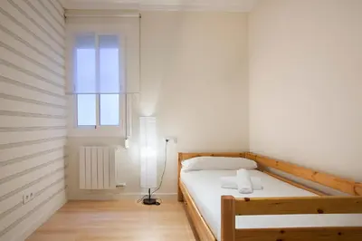 a bedroom with a bed and a lamp and a window at BBarcelona Aragó Flat in Barcelona