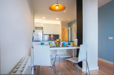 a kitchen with white chairs and a white counter top at BBarcelona Aragó Flat in Barcelona