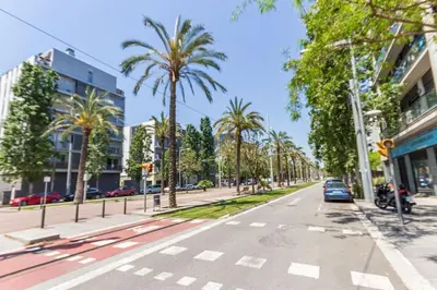 an empty street with palm trees in a city at Piso en zona fòrum con vistas al mar in Barcelona