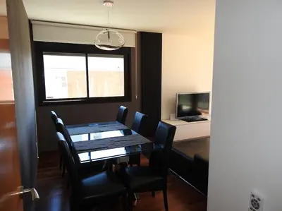 a dining room with a table and chairs and a television at Piso en zona fòrum con vistas al mar in Barcelona