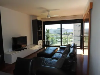 a living room with a couch and a large window at Piso en zona fòrum con vistas al mar in Barcelona