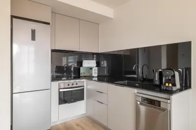 a kitchen with white cabinets and stainless steel appliances at Stay U-nique Apartment Corsega II in Barcelona