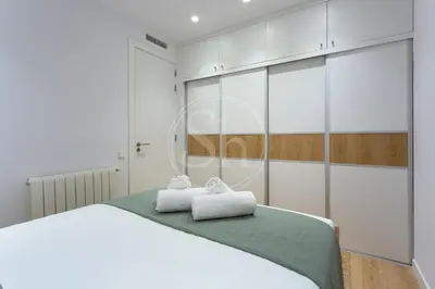 a white bedroom with a white bed and white cabinets at Maravilloso alojamiento con vistas a Barcelona in Barcelona