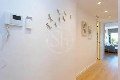 a living room with a white wall with birds on the wall at Maravilloso alojamiento con vistas a Barcelona in Barcelona