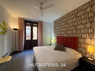 a bedroom with a large bed with a red headboard at Palau de la música 5 in Barcelona